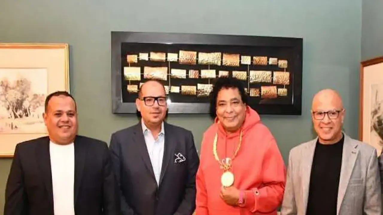 محمد منير يتسلم قلادة العظماء من ياسر إدريس خلال تكريمه كسفير اللجنة الأولمبية